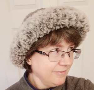 woman wearing a gray knitted hat with faux fur trim