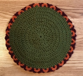 Round crochet hot pad in olive green
